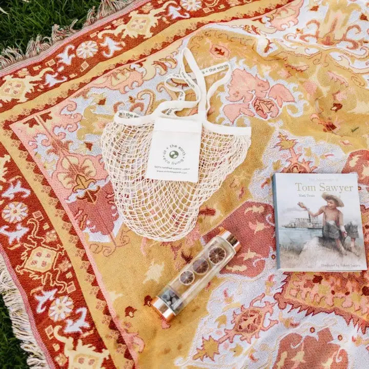 A Reusable Shopping Net Bag placed on a carpet beside a sparkling crystal water bottle, highlighting eco-friendly living.